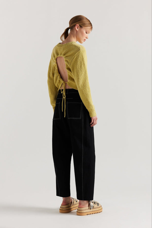 Back of model in the yellow Levity Tie Top with open back and adjustable tubular ties in soft cotton–nylon knit