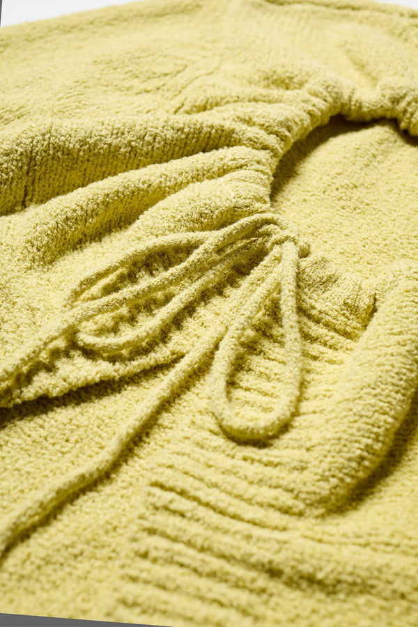 Fabric detail of the yellow Levity Tie Top with open back and adjustable tubular ties in soft cotton–nylon knit