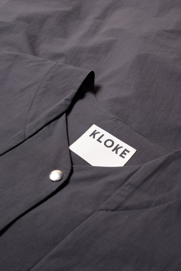 Detail of the Slate Locate Jacket’s rounded neckline and button detail. 