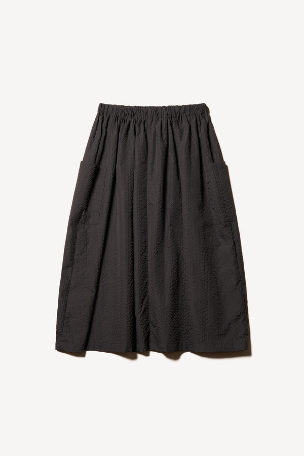 Flat back of the Jet black Minor Skirt, an A-line midi skirt with an elastic waistband and soft gathered detailing, in lightweight Japanese seersucker.