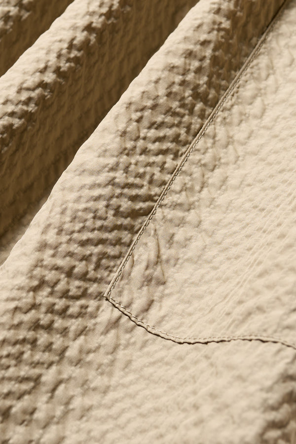 Close up fabric shot of the Stone/Beige Minor Skirt, an A-line midi skirt with an elastic waistband and soft gathered detailing, in lightweight Japanese seersucker.