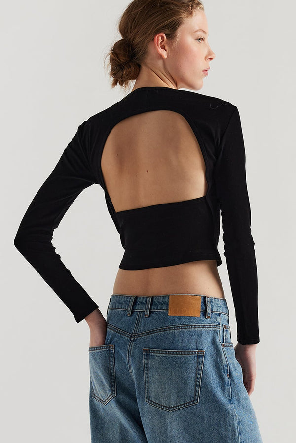 Back of female model in the Mist Ballet Top in black, long sleeve silhouette.