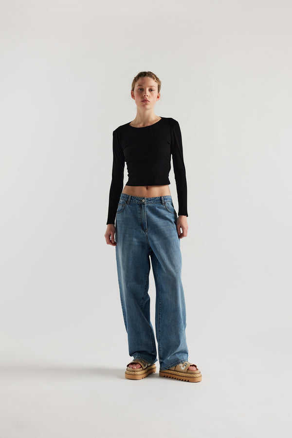 Front of female model in the Mist Ballet Top in black, long sleeve silhouette.