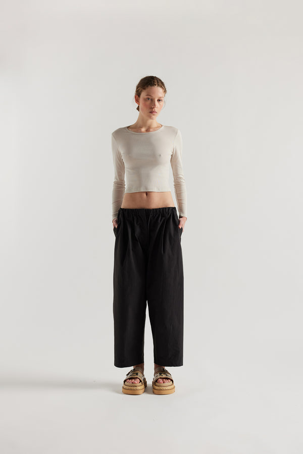 Front of female model in the Mist Ballet Top in bone off white, long sleeve silhouette.