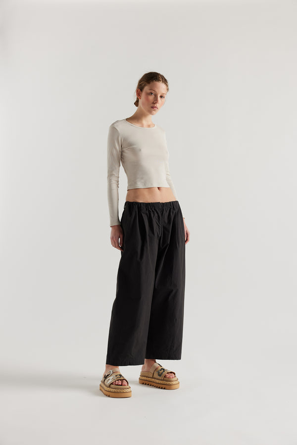 Front of female model in the Mist Ballet Top in bone off white, long sleeve silhouette.