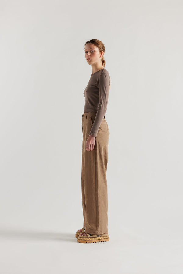 Side view of female model in the Mist Ballet Top in fawn brown, long sleeve silhouette.