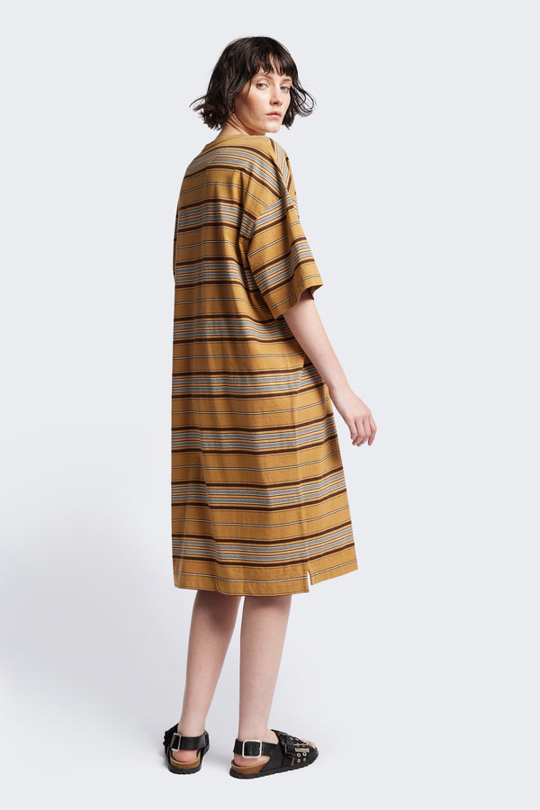 Back of The Nadir Dress in tan stripe, a laid-back style made from pure cotton jersey. This knee-length dress features side-splits, dropped shoulder, and elbow-grazing sleeves. Available in 5 sizes. 
