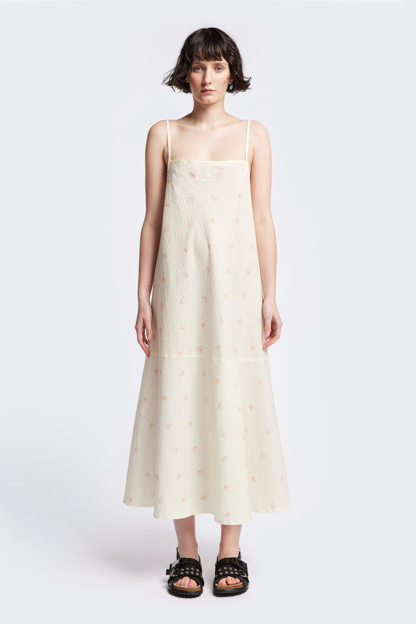 Front of the Natant Dress in ecru floral, a Maxi-length Natant Dress with adjustable thin straps, a straight neckline, and a bias-cut silhouette, made from lightweight printed seersucker. Available in 5 sizes. 