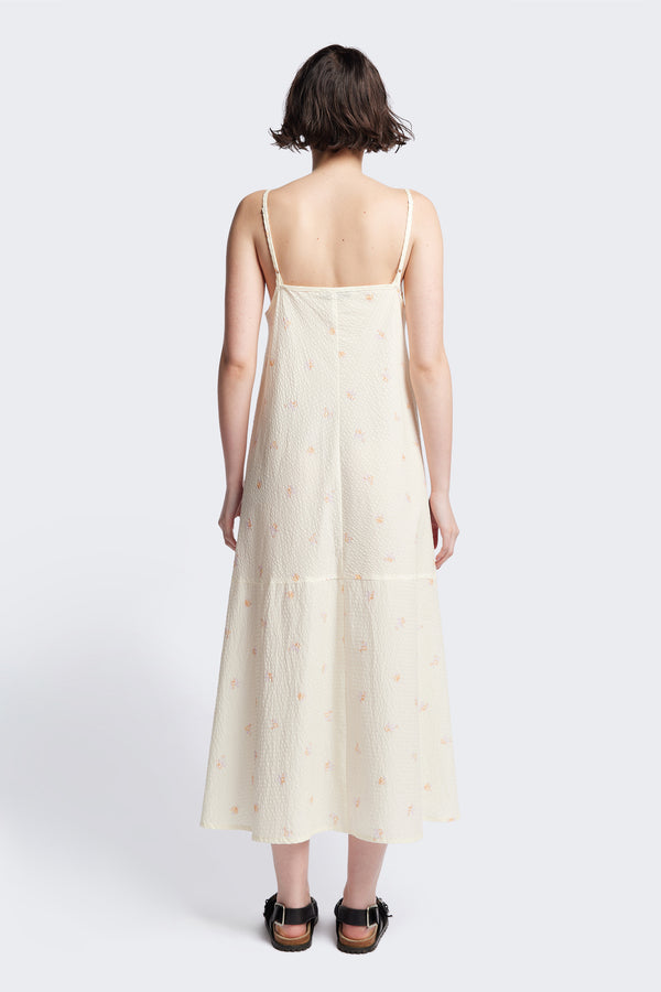 Back of the Natant Dress in ecru floral, a Maxi-length Natant Dress with adjustable thin straps, a straight neckline, and a bias-cut silhouette, made from lightweight printed seersucker. Available in 5 sizes. 