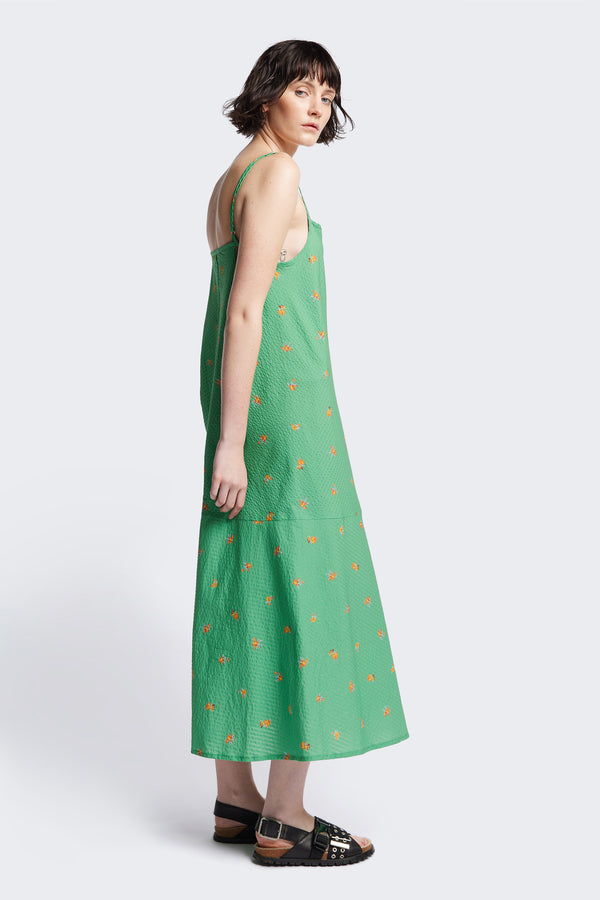 Side of The Natant Dress in green floral, a Maxi-length Natant Dress with adjustable thin straps, a straight neckline, and a bias-cut silhouette, made from lightweight printed seersucker. Available in 5 sizes. 