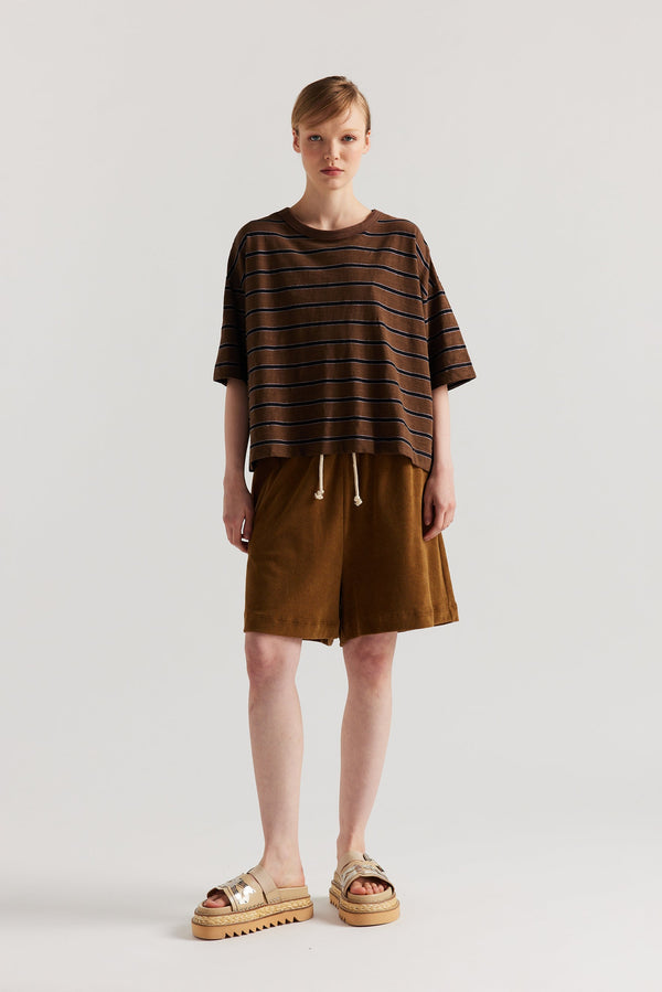 Front view of model in the black/brown/lilac stripe, Obelisk Feeder Stripe Tee in yarn-dyed slub cotton with relaxed boxy fit