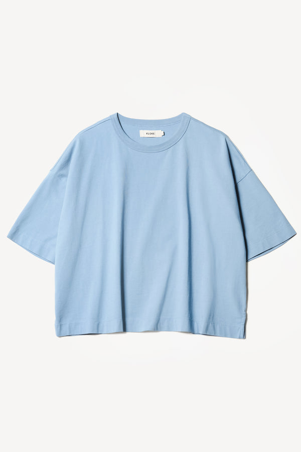 flat front of Obelisk Tee in blue, showing relaxed fit and straight hem with side split