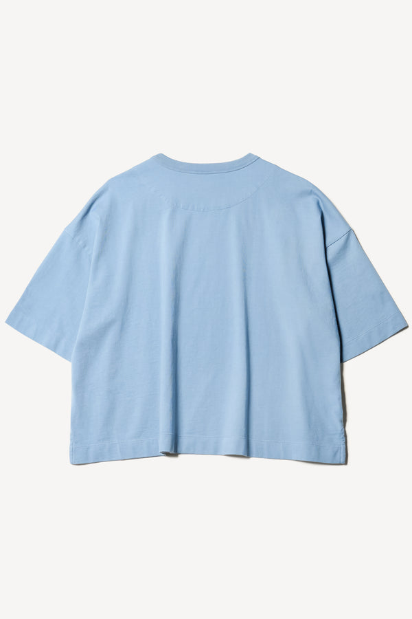 flat back of Obelisk Tee in blue, showing relaxed fit and straight hem with side split