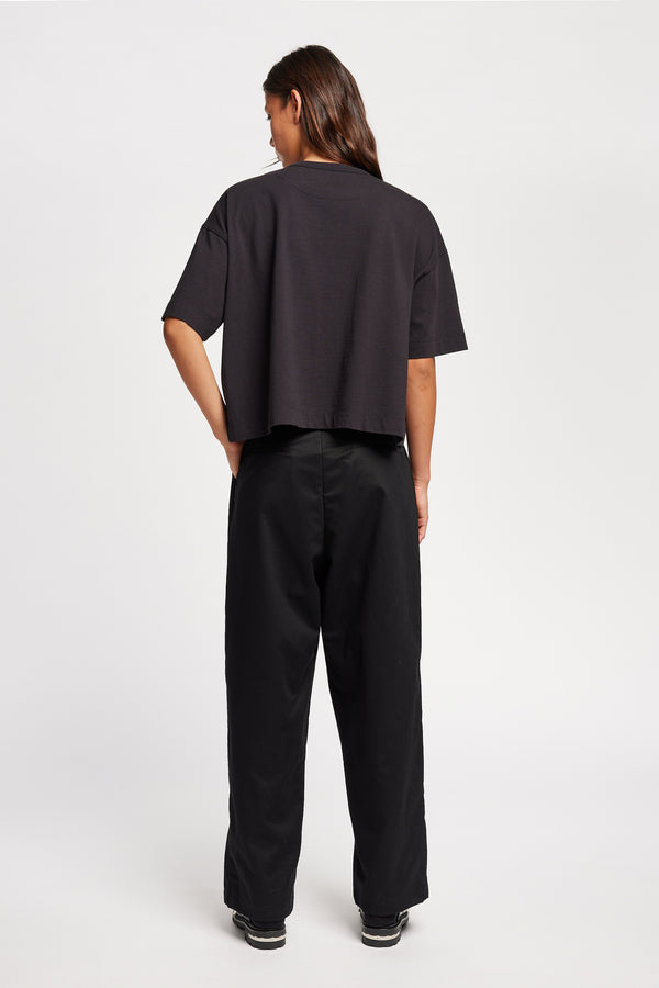 Back of Model wearing Obelisk Tee in Jet Black, showcasing oversized silhouette and dropped shoulders