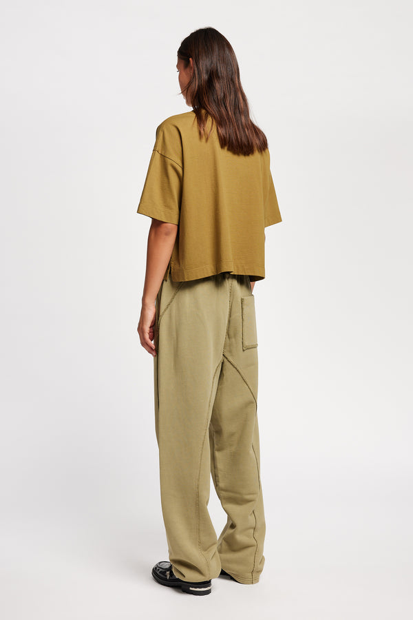 Back view of Model wearing Obelisk Tee in Olive Oil, showcasing oversized silhouette and dropped shoulders