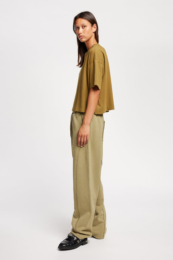 Side view of Model wearing Obelisk Tee in Olive Oil, showcasing oversized silhouette and dropped shoulders