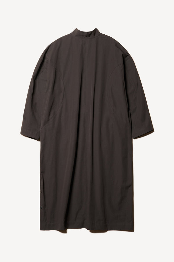 Flat back of the Odeum Dress in black mid-weight cotton, featuring a high mock collar and large utility pockets.