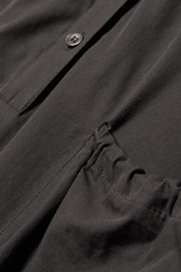 Close up fabric detail shot of the Odeum Dress pocket detail in black mid-weight cotton. 