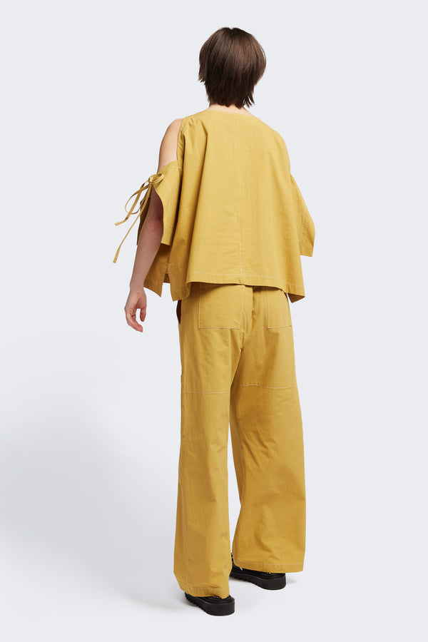 Back view of the Open Shoulder Top in mustard. Featuring a relaxed fit and side-tie sleeve details.