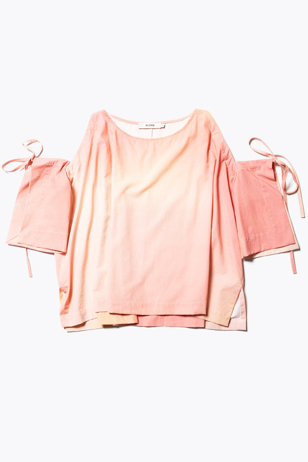 Flat Front view of the Open Shoulder Top in pink/ orange cloud print. Featuring a relaxed fit and side-tie sleeve details.