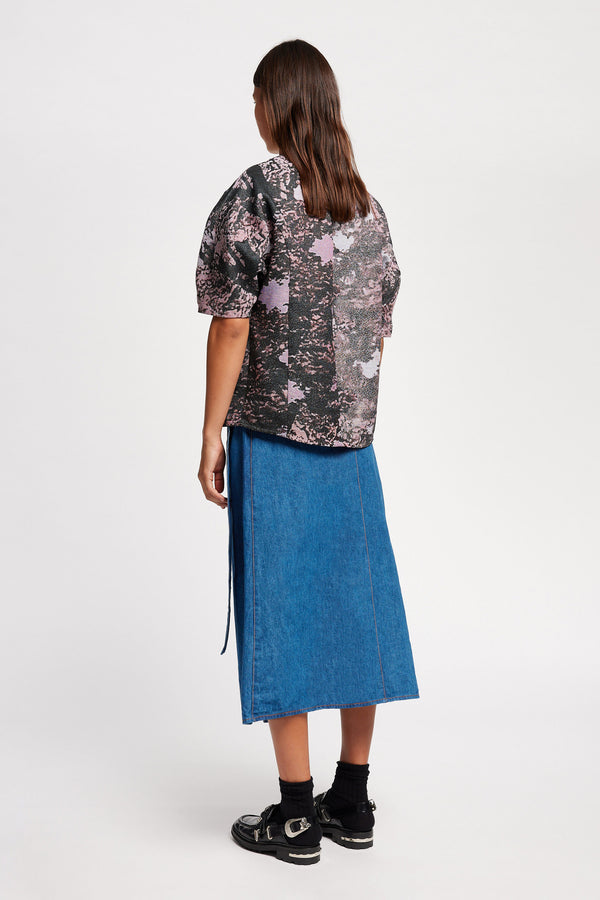 Back of the model in the forge top in purple print featuring a unique woven jacquard fabric with real tree camouflage pattern, sculptured panelled sleeves, and a contemporary fit