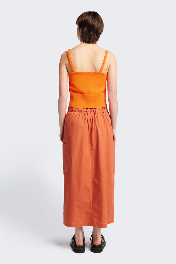 The back of the Opus Skirt Rust, a straight, mid length skirt with an elasticated waist. Styled with the Peril Knit Tank Orange. 