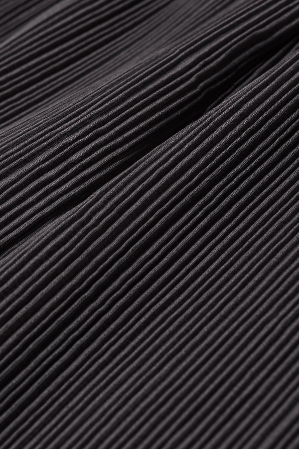Close up fabric shot of the Loose-fit crinkle top in black made from Japanese recycled polyester, featuring panelled seams and a textured finish.