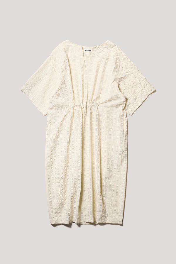 Flat front of the Origin Dress in gingham seersucker butter check. A relaxed silhouette with internal tie, clean neckline, and subtle underarm split detail.