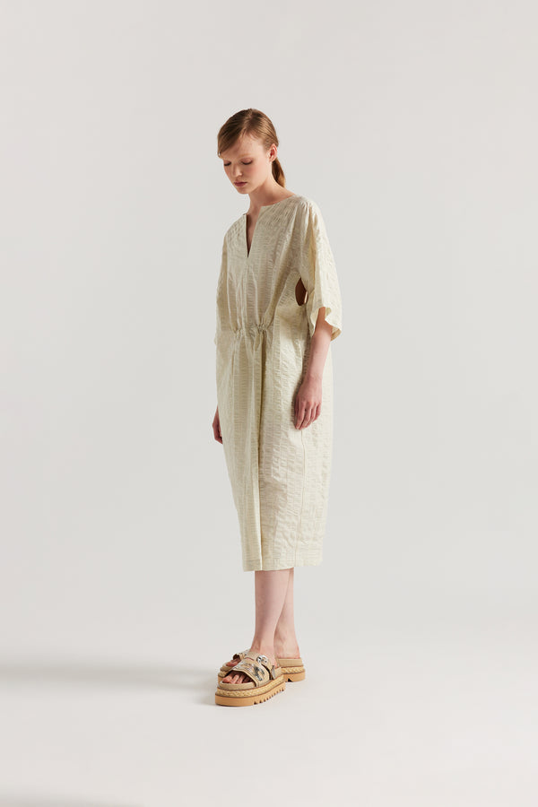 Front angle view of Woman wearing the Origin Dress in gingham seersucker butter check. A relaxed silhouette with internal tie, clean neckline, and subtle underarm split detail.