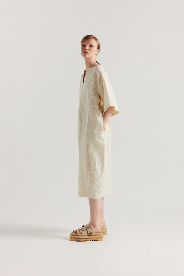 Side view of Woman wearing the Origin Dress in gingham seersucker butter check. A relaxed silhouette with internal tie, clean neckline, and subtle underarm split detail.