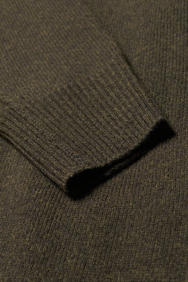 Close up fabric details of the Overflow long knit, high neck wool blend sweater with exposed seams in darkest green