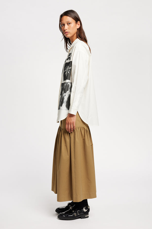 Side of Model wearing the Pano shirt, an off-white printed shirt with relaxed fit, structured collar, and vintage-photo placement print.