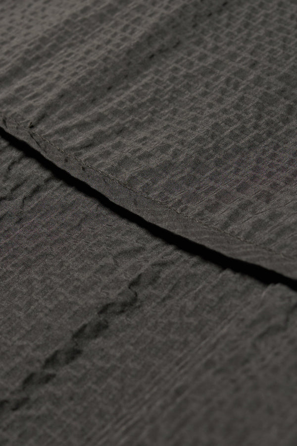 Close up fabric detail shot of the Parapet Dress in Jet Black lightweight seersucker nylon.