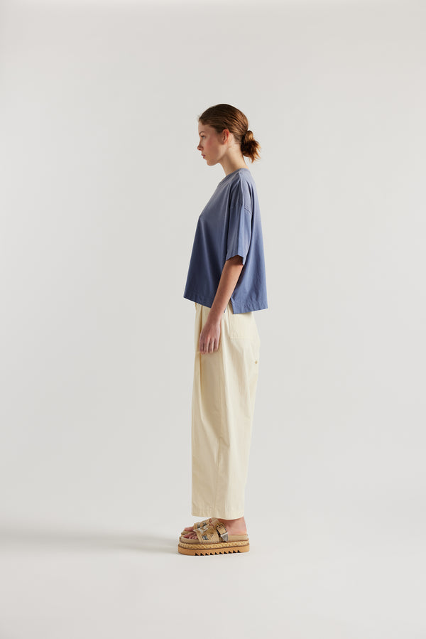 Side of Model wearing Passage Tee in blue, showcasing oversized silhouette and dropped shoulders