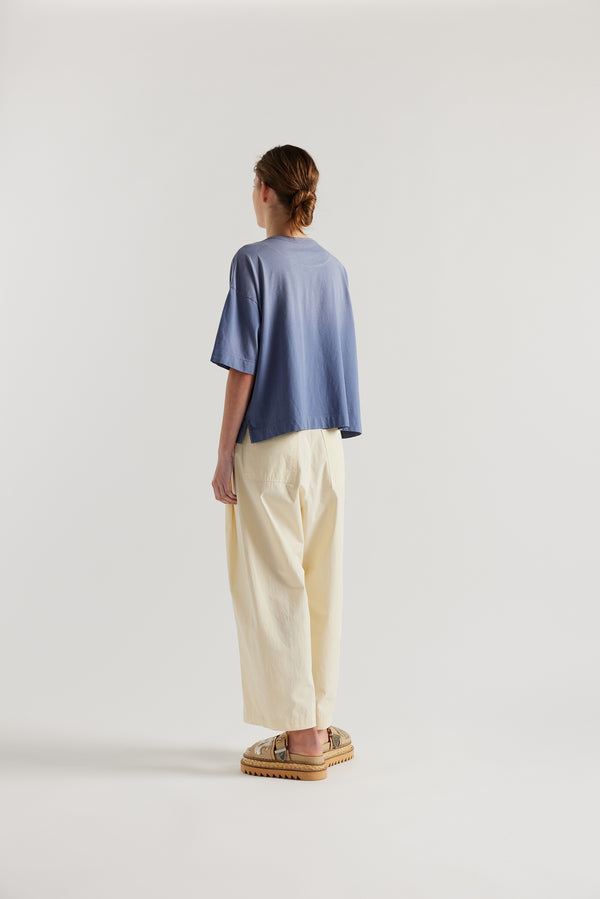 Back of Model wearing Passage Tee in blue, showcasing oversized silhouette and dropped shoulders