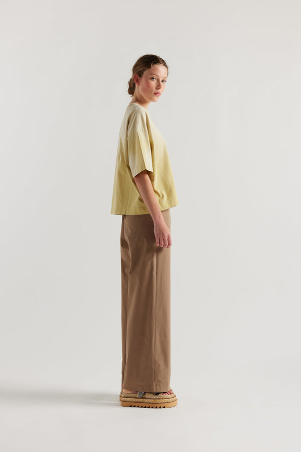 Side of Model wearing Passage Tee in chartreuse, showcasing oversized silhouette and dropped shoulders