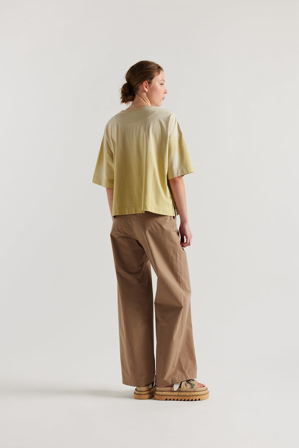 Back of Model wearing Passage Tee in chartreuse, showcasing oversized silhouette and dropped shoulders