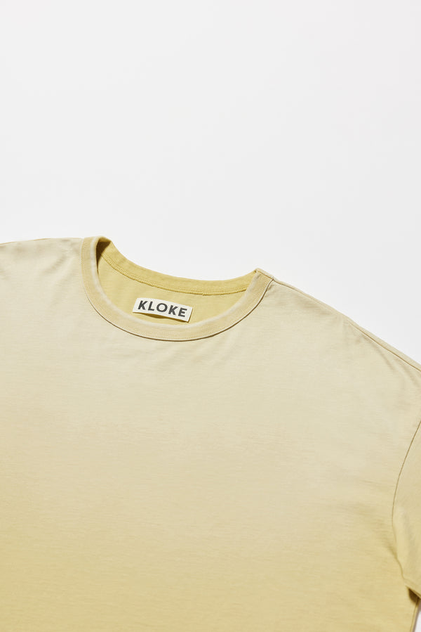 Details of the Passage Tee in chartreuse, showcasing oversized silhouette and dropped shoulders