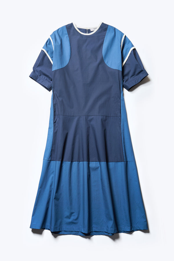 Flat front of The Patch dress in Blue, a colour-block dress with tonal hues, contrast-bound seams, round neckline with keyhole back, dropped sleeves with tucks, and a slightly flared skirt, perfect for a summer vibe.