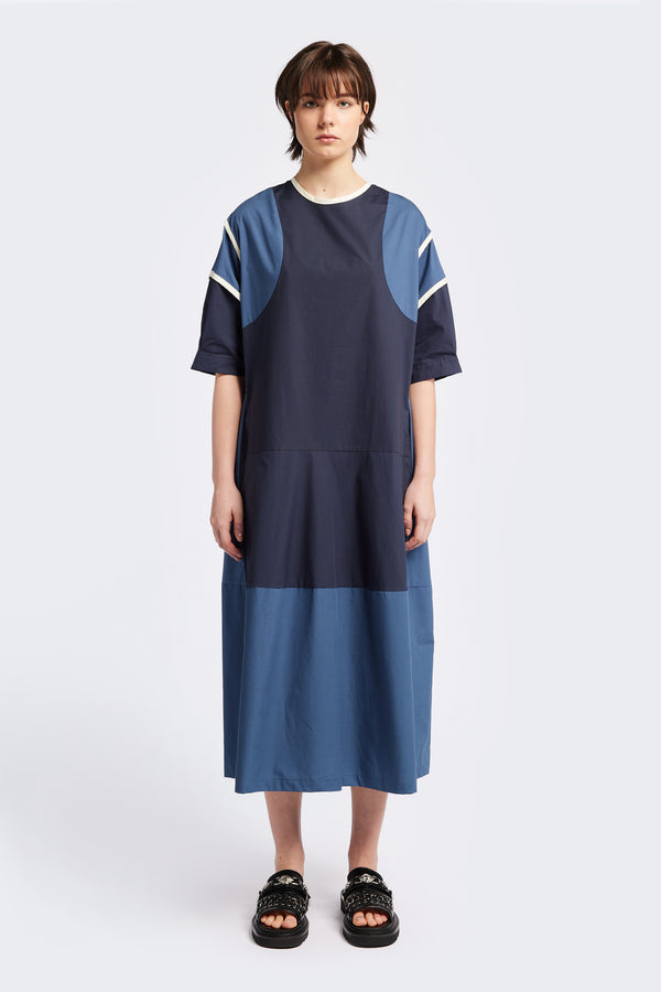 Front of The Patch dress in Blue, a colour-block dress with tonal hues, contrast-bound seams, round neckline with keyhole back, dropped sleeves with tucks, and a slightly flared skirt, perfect for a summer vibe.