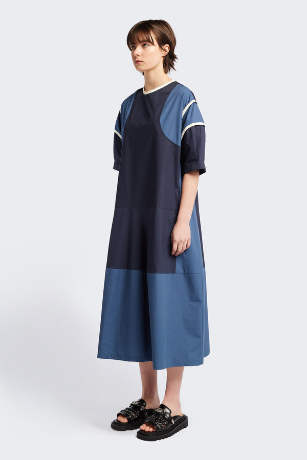 Front of The Patch dress in Blue, a colour-block dress with tonal hues, contrast-bound seams, round neckline with keyhole back, dropped sleeves with tucks, and a slightly flared skirt, perfect for a summer vibe.