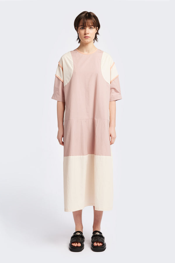 Front of The Patch dress in Peach, a colour-block dress with tonal hues, contrast-bound seams, round neckline with keyhole back, dropped sleeves with tucks, and a slightly flared skirt, perfect for a summer vibe.