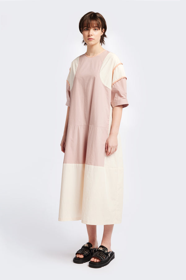 Front of The Patch dress in Peach, a colour-block dress with tonal hues, contrast-bound seams, round neckline with keyhole back, dropped sleeves with tucks, and a slightly flared skirt, perfect for a summer vibe.