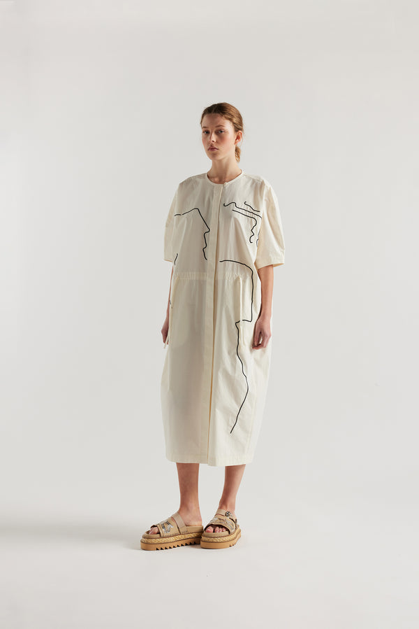 front view of female model in the ecru Pensive Dress with black embroidered motifs and round neckline