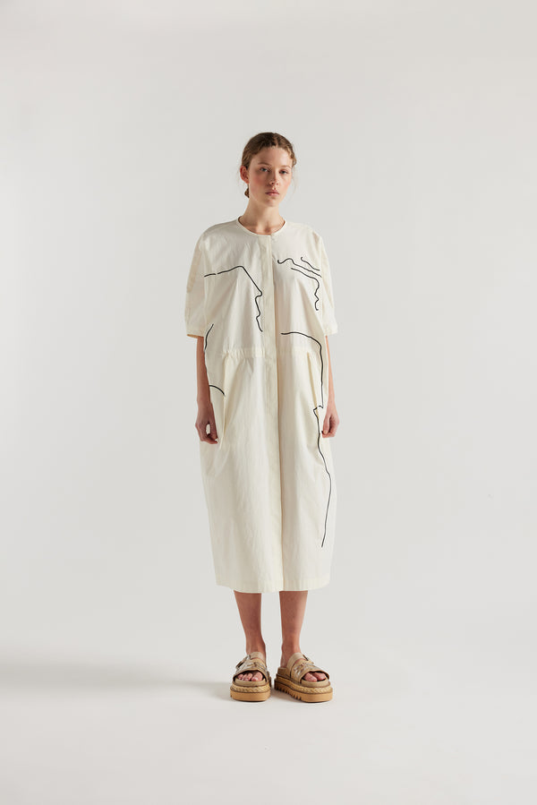 front view of female model in the ecru Pensive Dress with black embroidered motifs and round neckline