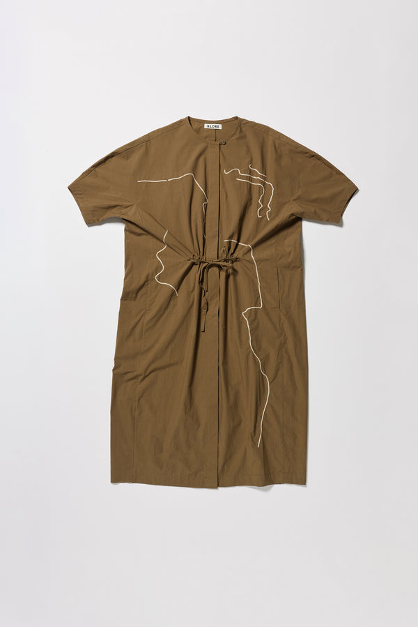 Flat front of the Olive Pensive Dress with black embroidered motifs and highlighting the encased self tie waist cinched in