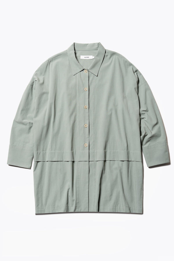 Flat Front of the Plein Long Sleeve Shirt in Olive Green. An oversized panel shirt with a cocoon back, front tuck, and pleated dropped sleeves, can be styled as a lightweight jacket.