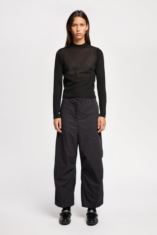Front of Model wearing the Premise Cargo in Jet Black, a relaxed-fit pant with adjustable waistband, clean front pleats, and straight-leg silhouette.