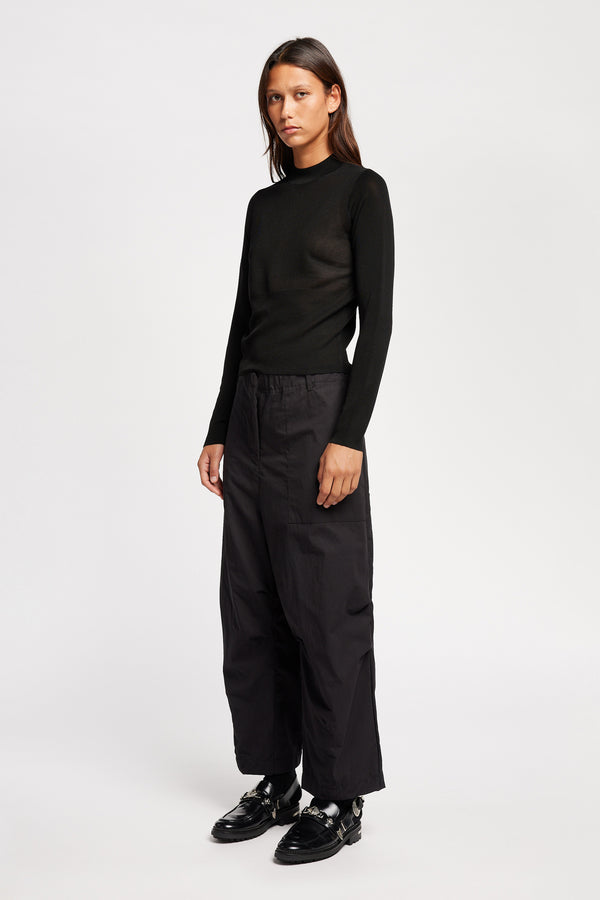 Front of Model wearing the Premise Cargo in Jet Black, a relaxed-fit pant with adjustable waistband, clean front pleats, and straight-leg silhouette.
