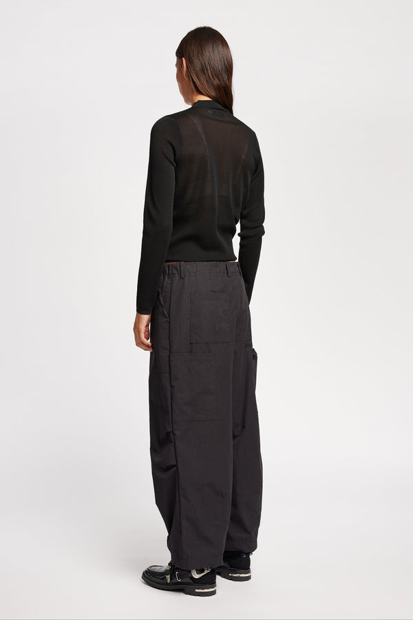 Back of Model wearing the Premise Cargo in Jet Black, a relaxed-fit pant with adjustable waistband, clean front pleats, and straight-leg silhouette.